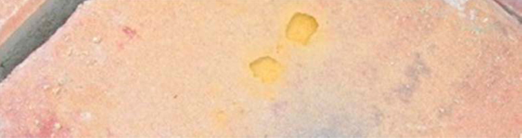 FIGURA 7. Defecto en la superficie de un adoquín por presencia de bolitas de pigmento.